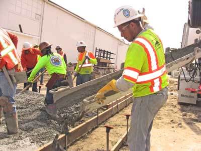 Apprentices pouring concrete